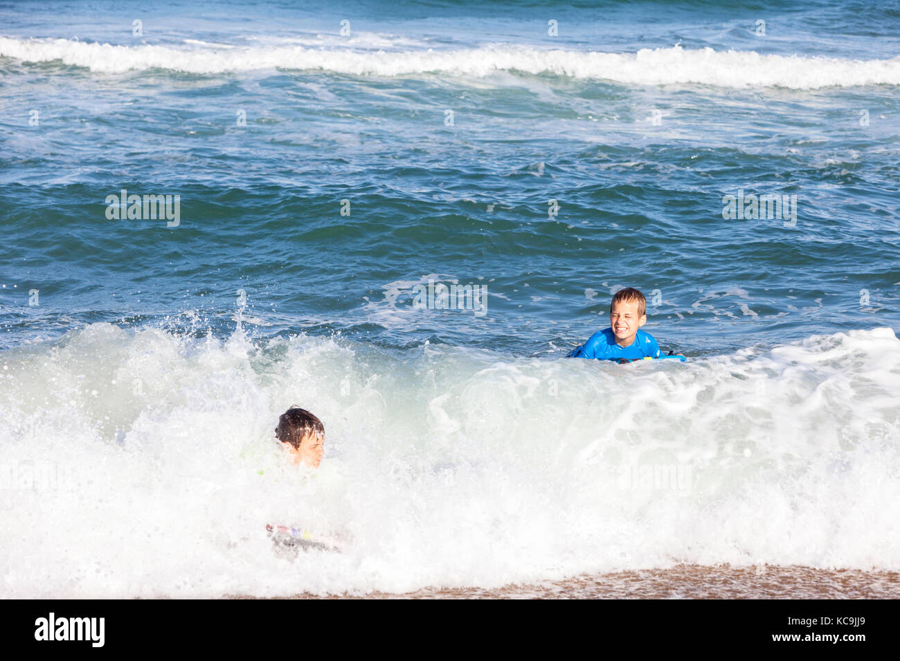 Avon, Outer Banks, North Carolina, USA.  Pre-teenage Boys in the Atlantic Surf with their Boogie Boards. Stock Photo