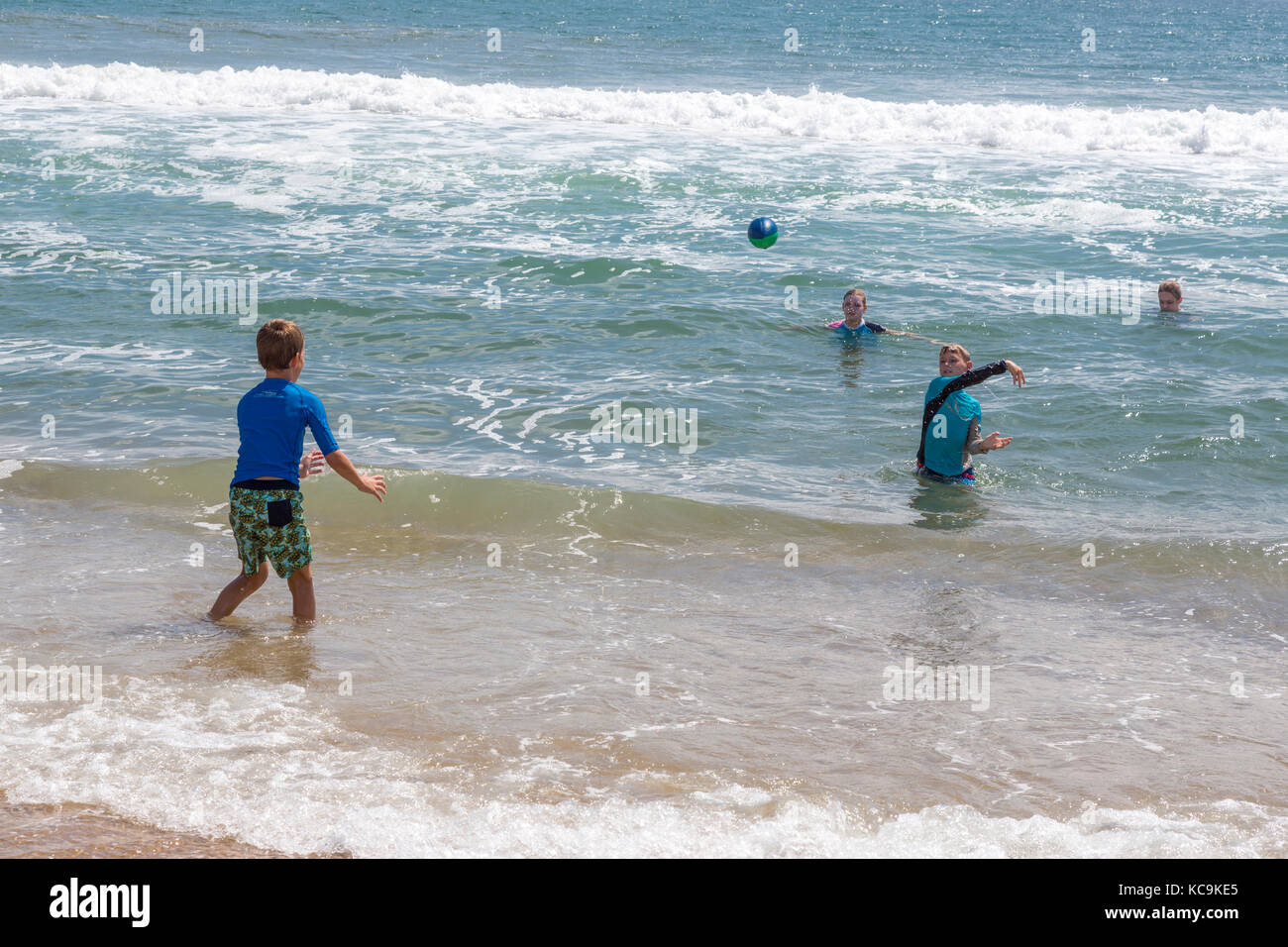 Avon, Outer Banks, North Carolina, USA.  Young American Boys in the Surf, Tossing Football. Stock Photo