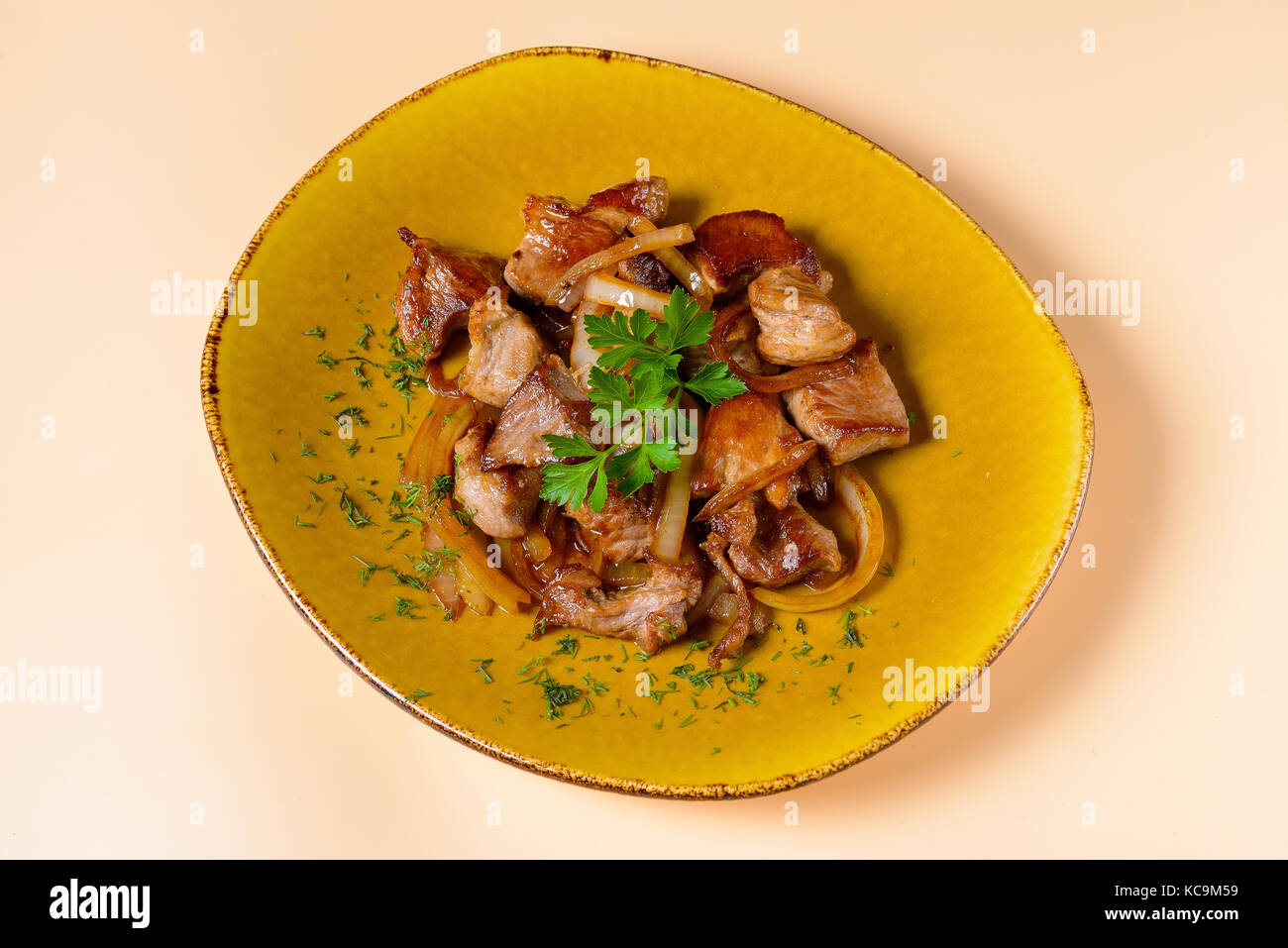 Fried meat with onions on plate Stock Photo