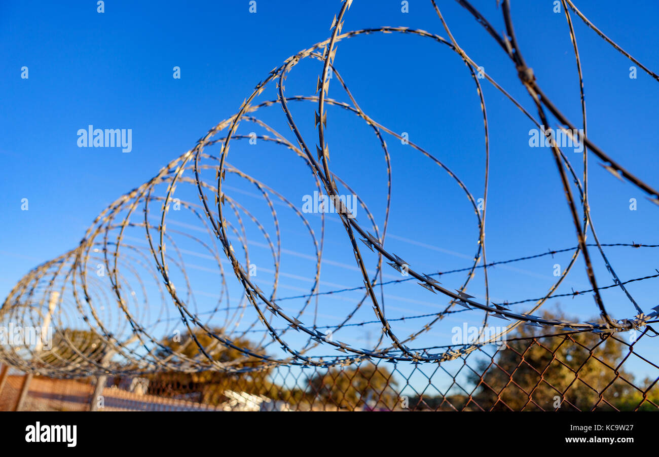 Fence with a barbed wire under a blue sky Stock Photo - Alamy