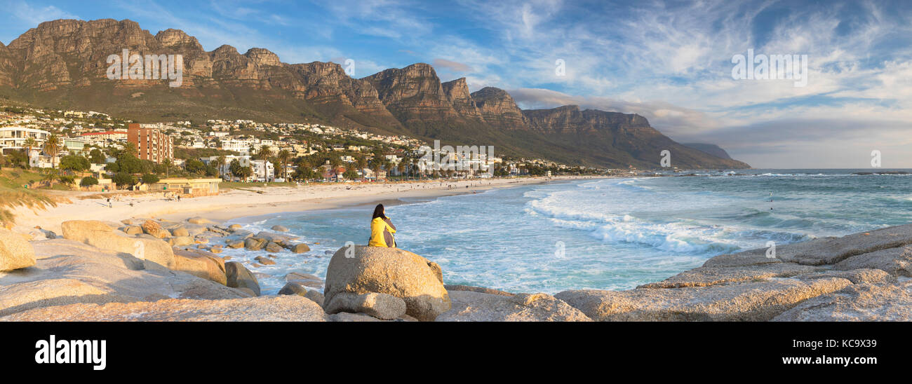 Woman sitting on rocks at Camps Bay, Cape Town, Western Cape, South Africa (MR) Stock Photo