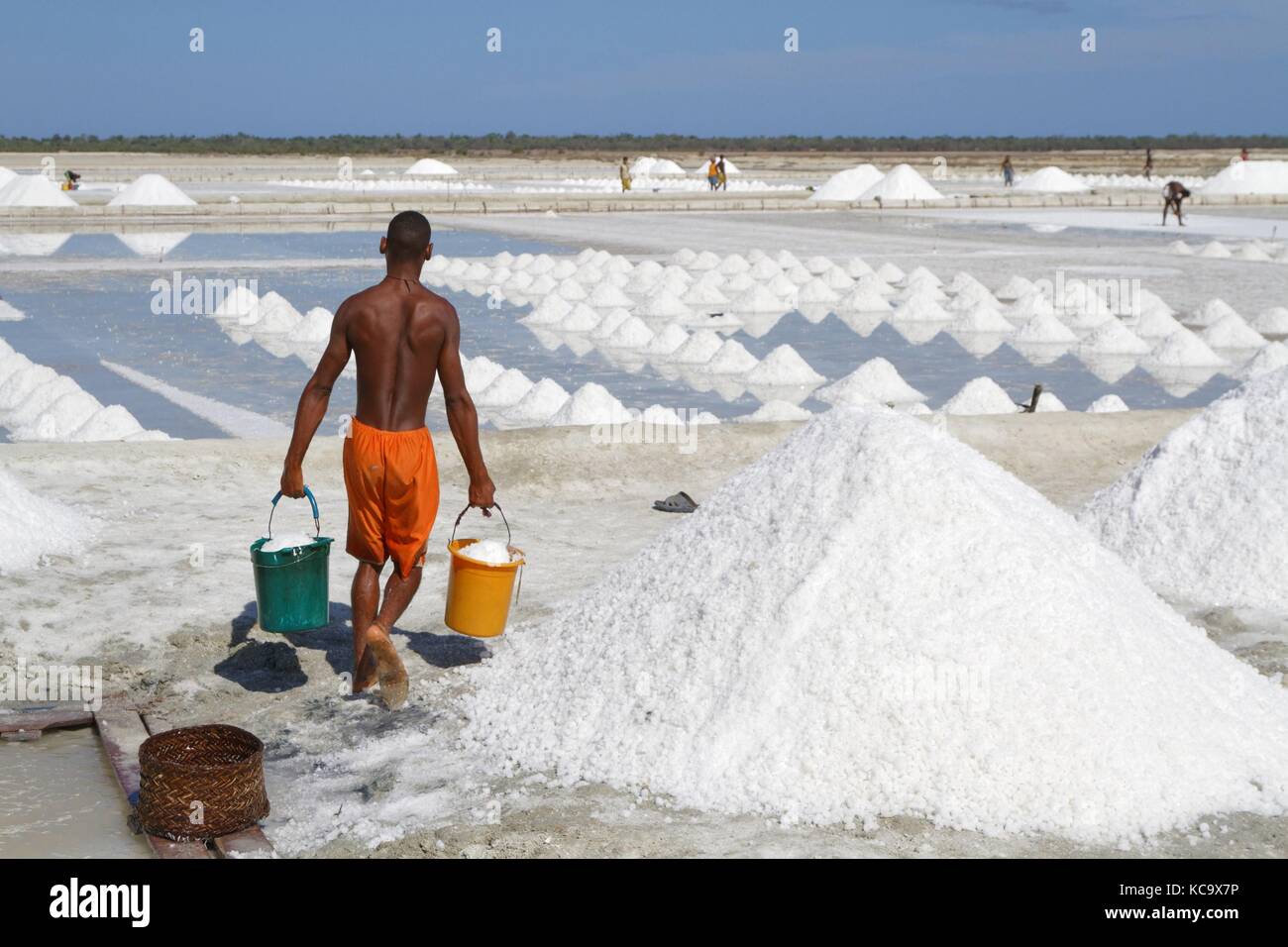 BELO, MADAGASCAR, November 24, 2015 : People works in salt evaporation ponds near Belo-sur-Mer, to extract salts from sea water. Stock Photo