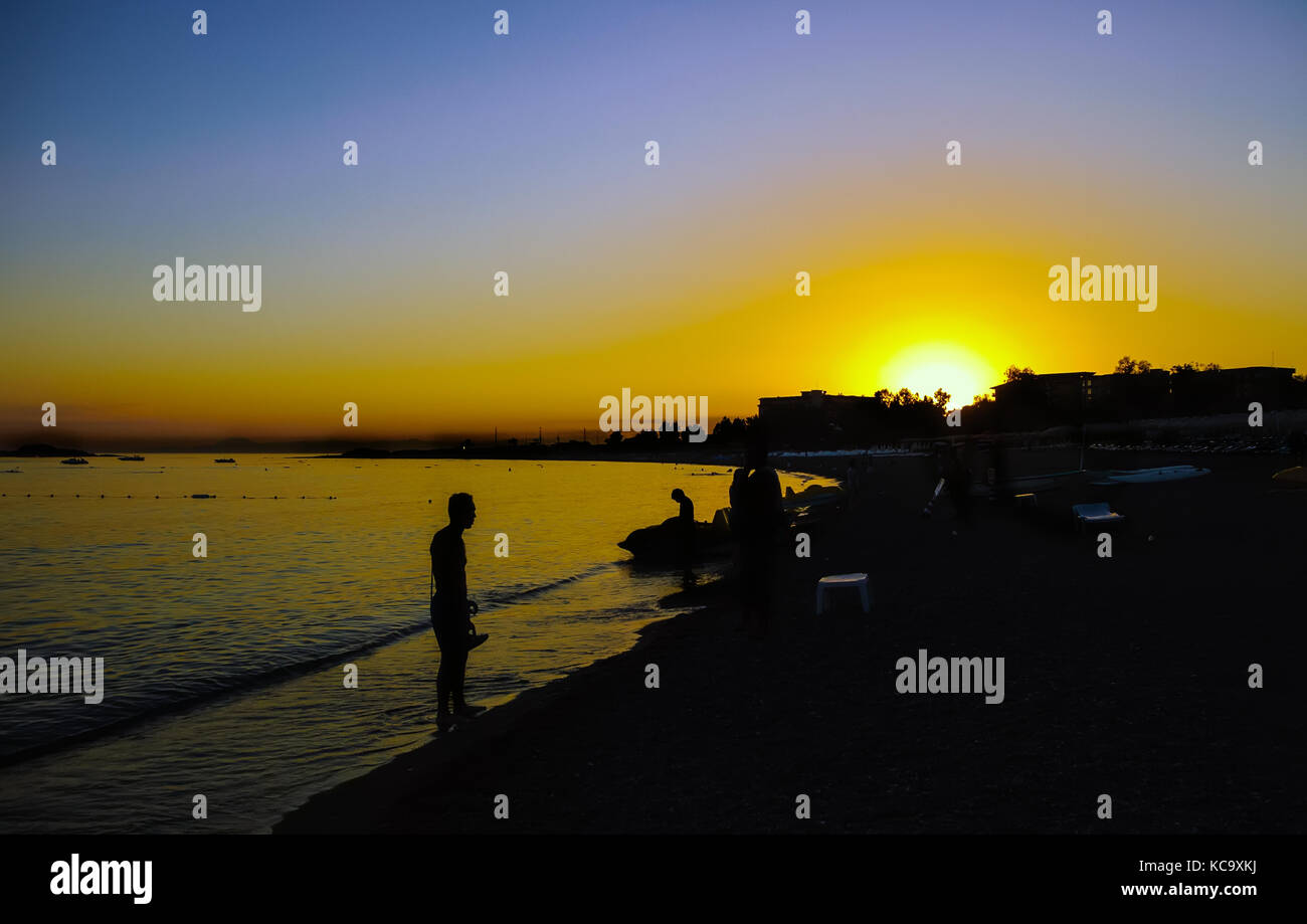 Man silhouette on the beach at sunset Stock Photo - Alamy