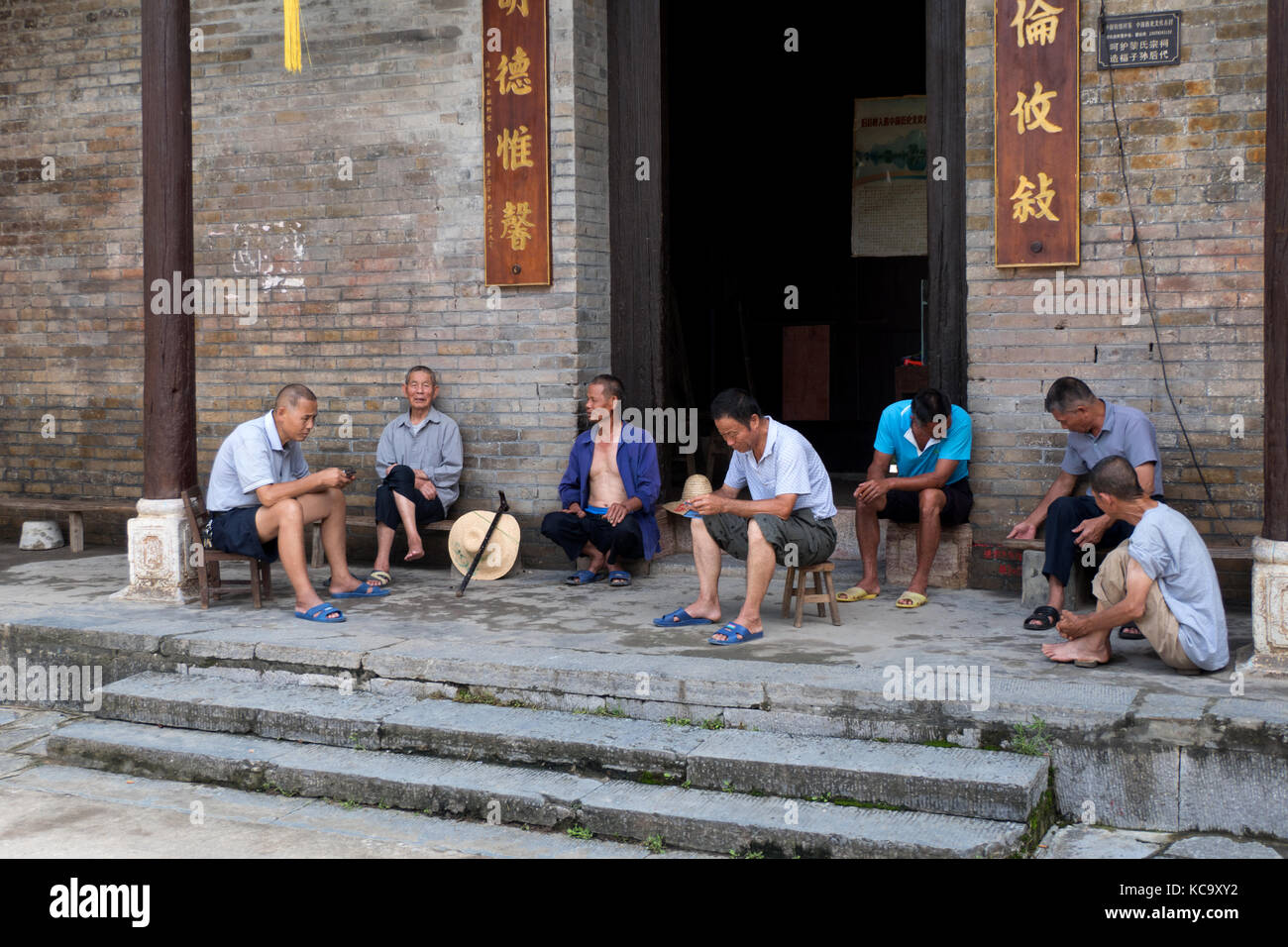Group of senior Chinese men relaxing, talking and smoking in Jiuxian village, Yangshuo County, Guangxi, China, Asia. Old friends having fun with leisu Stock Photo