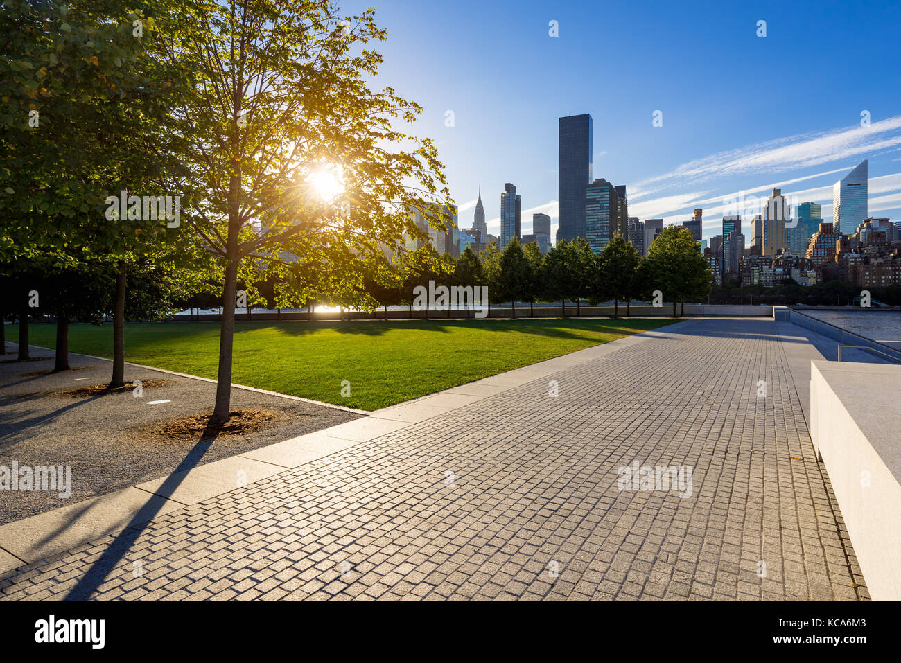 Sunset with  Manhattan Midtown East from paved walkway of Franklin D. Rosevelt Four Freedoms Park. Roosevelt Island, New York City Stock Photo