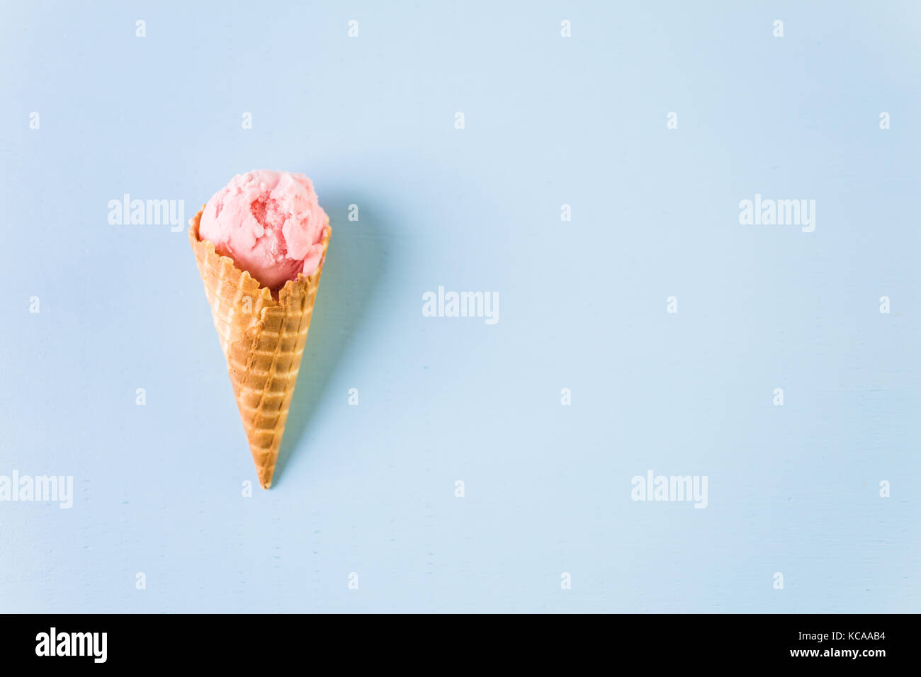 Waffle ice cream cones with scoops of ice cream on a blue background ...