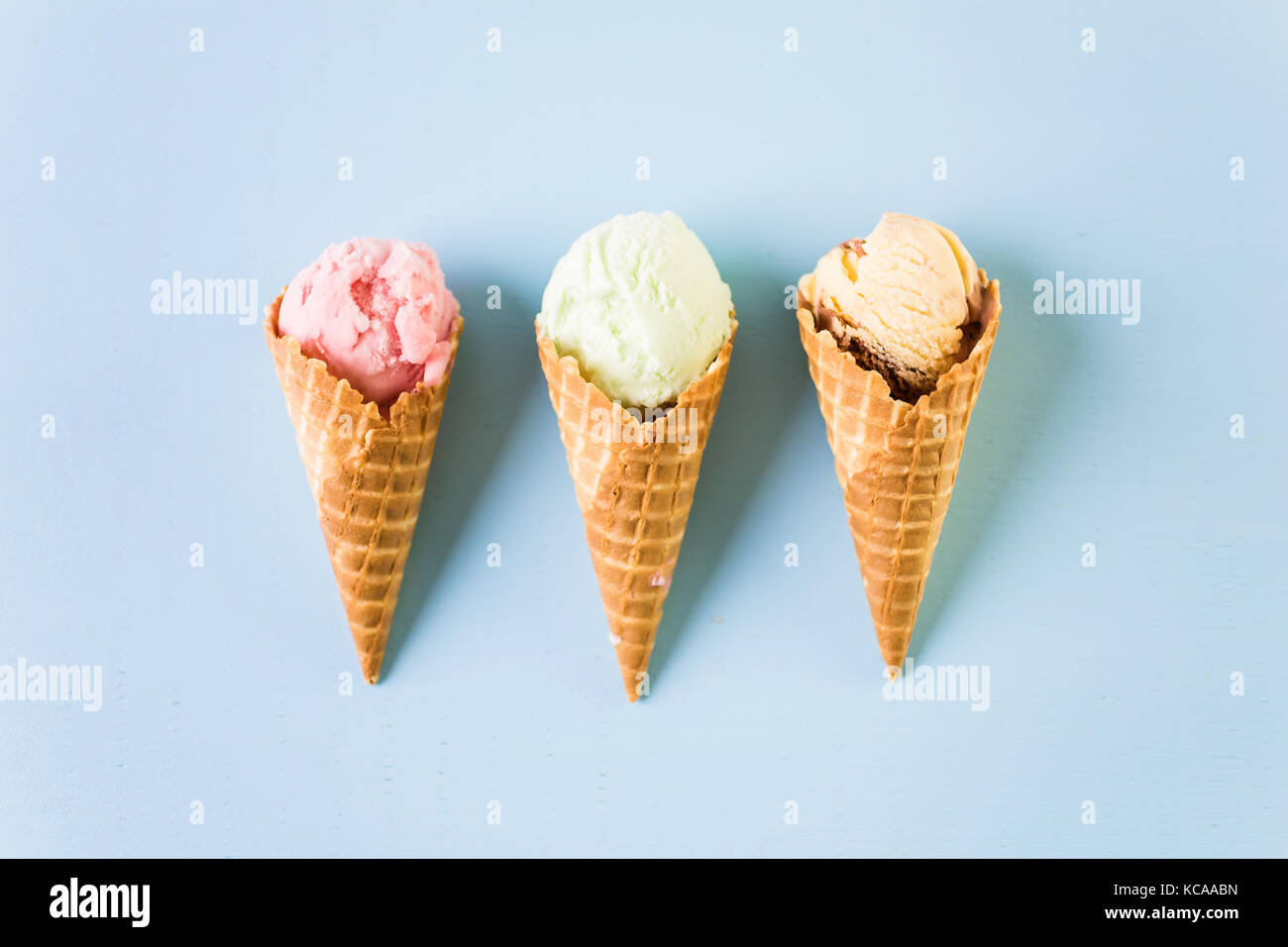 Waffle ice cream cones with scoops of ice cream on a blue background ...