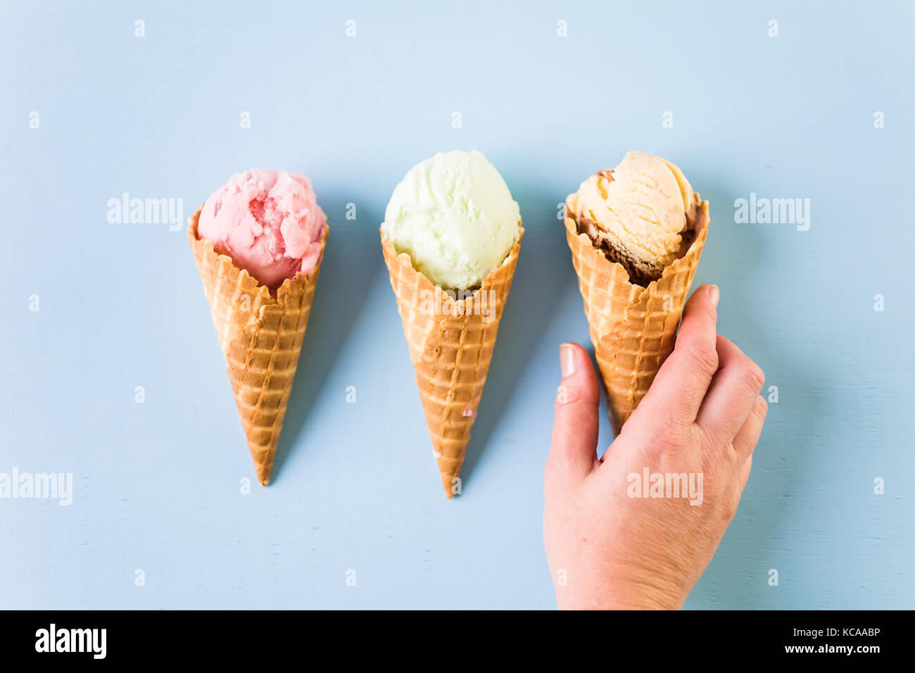 Waffle ice cream cones with scoops of ice cream on a blue background ...
