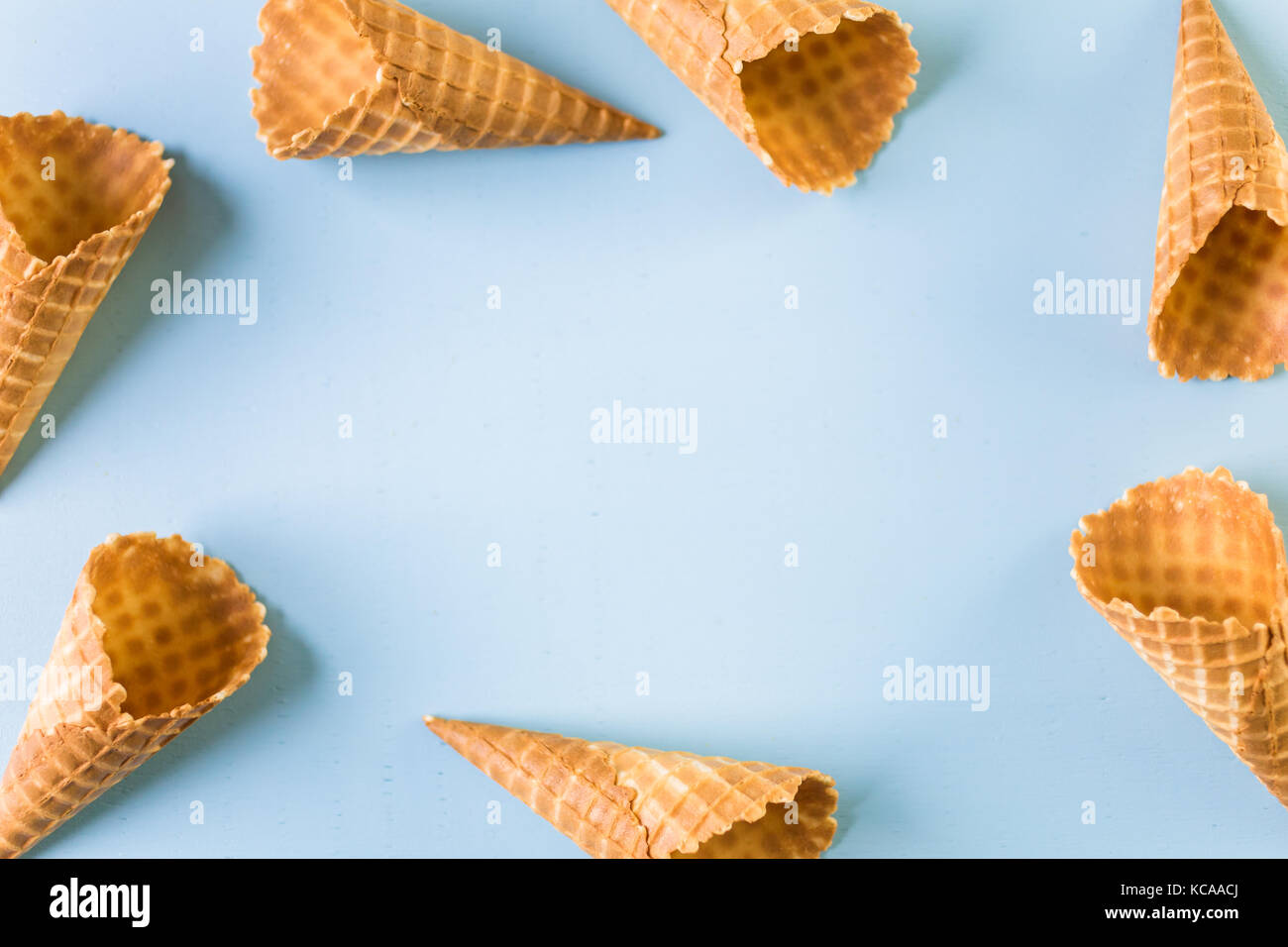 Waffle ice cream cones with scoops of ice cream on a blue background ...