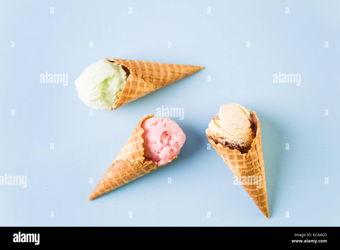 Waffle ice cream cones with scoops of ice cream on a blue background ...