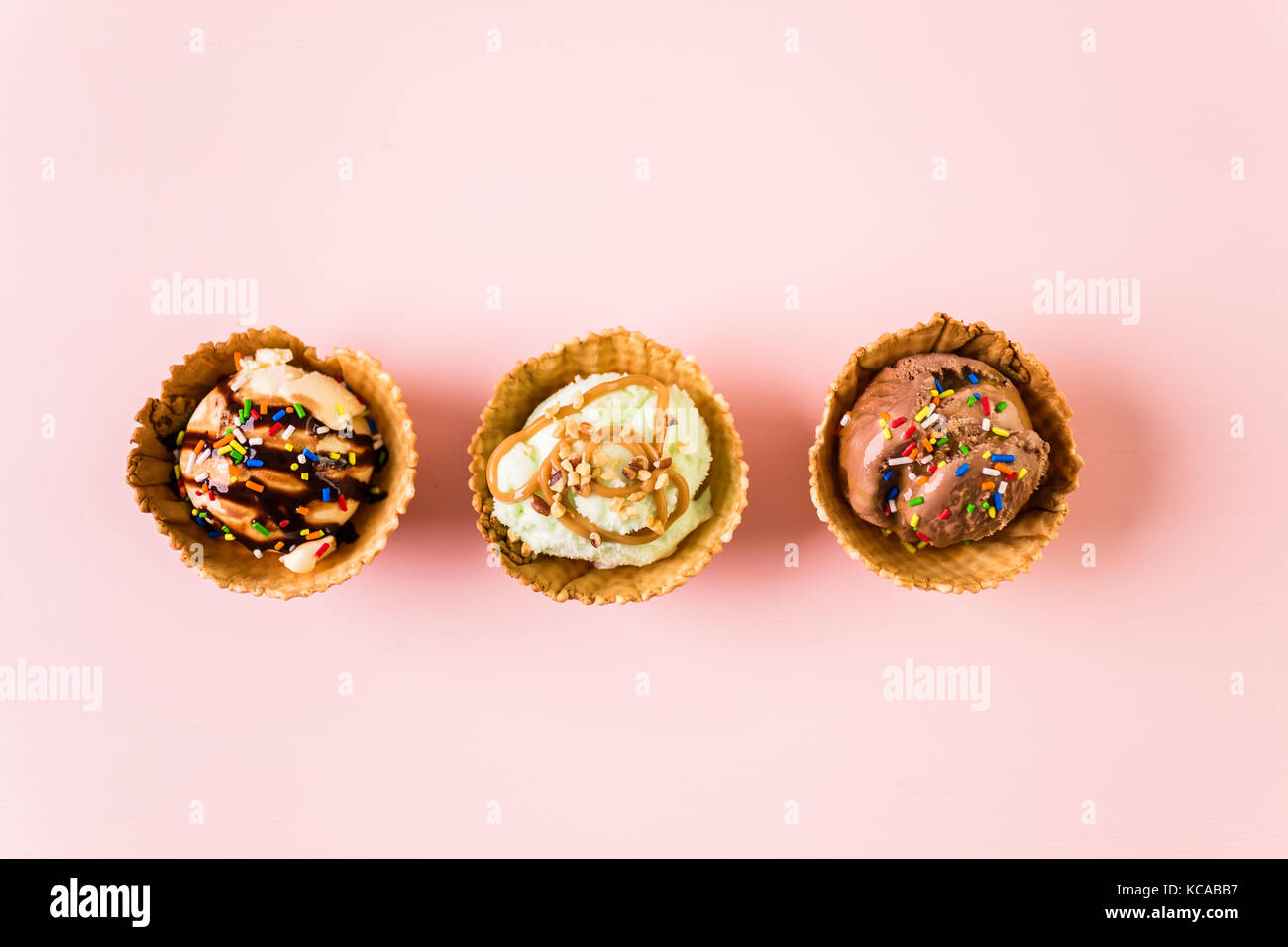 Waffle ice cream bowls with scoops of ice cream on a pink background