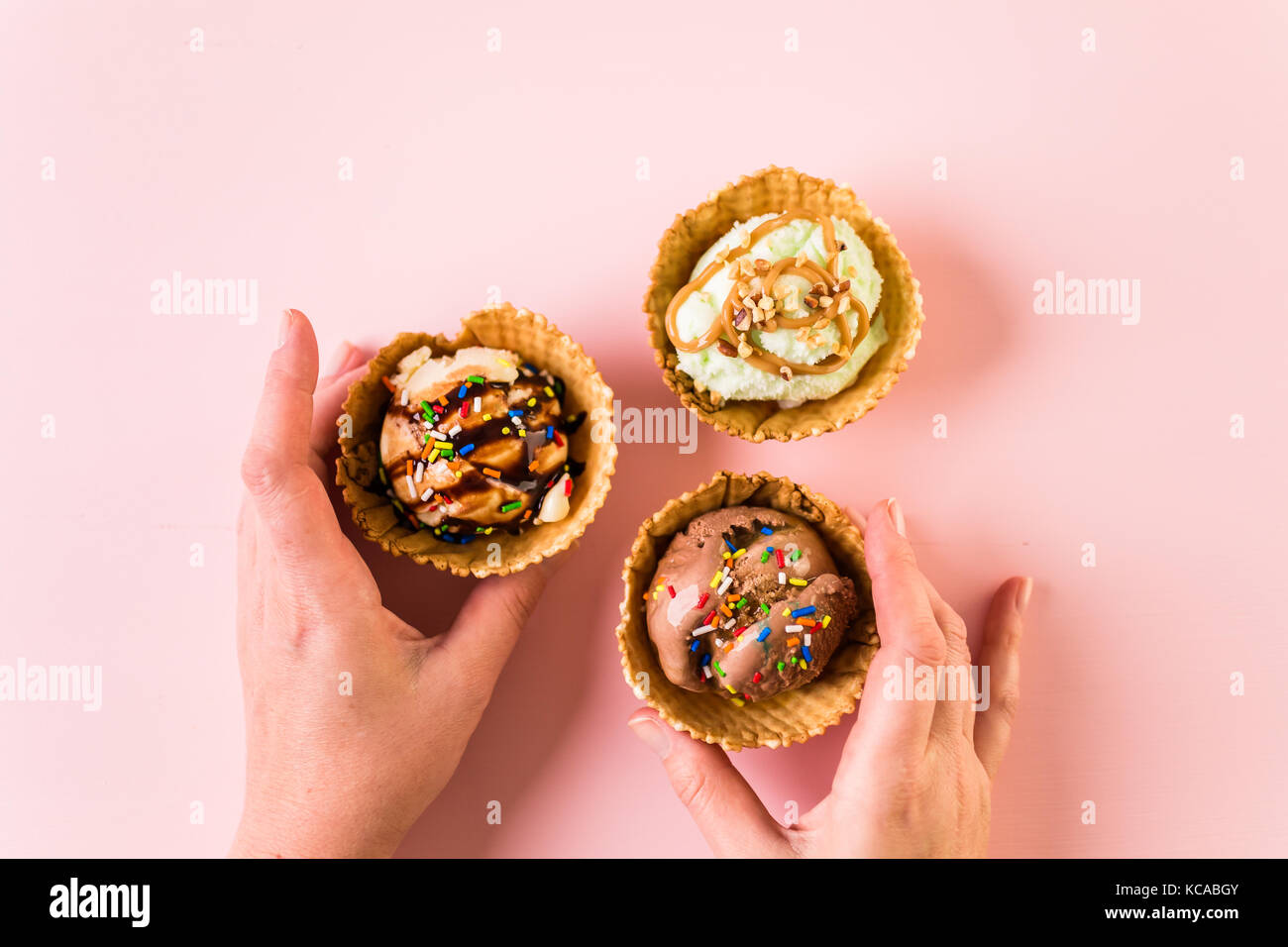 Waffle ice cream bowls with scoops of ice cream on a pink background