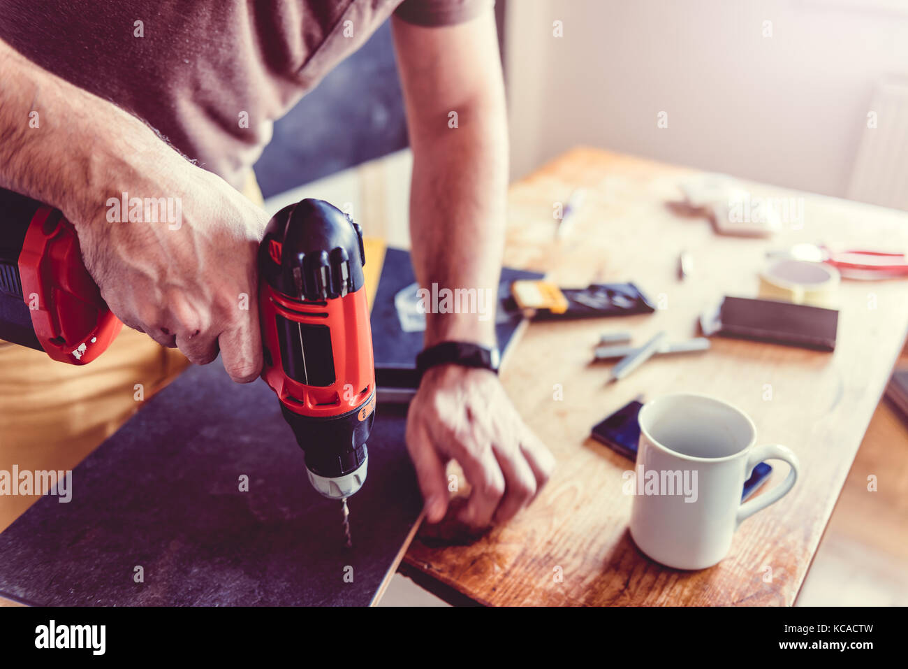 Man drilling laminate with power drill on the table Stock Photo Alamy