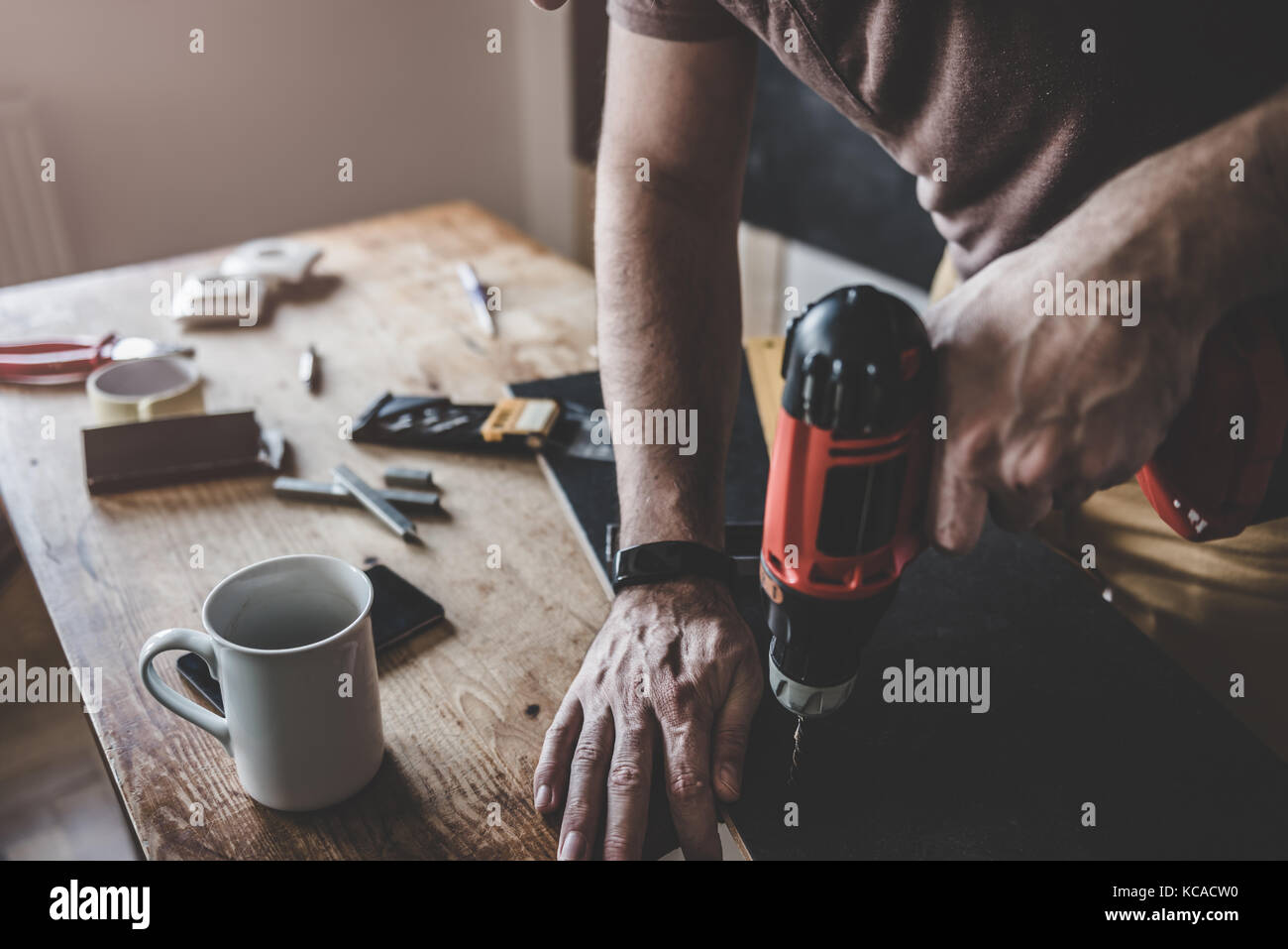 Man drilling laminate with power drill on the table Stock Photo Alamy