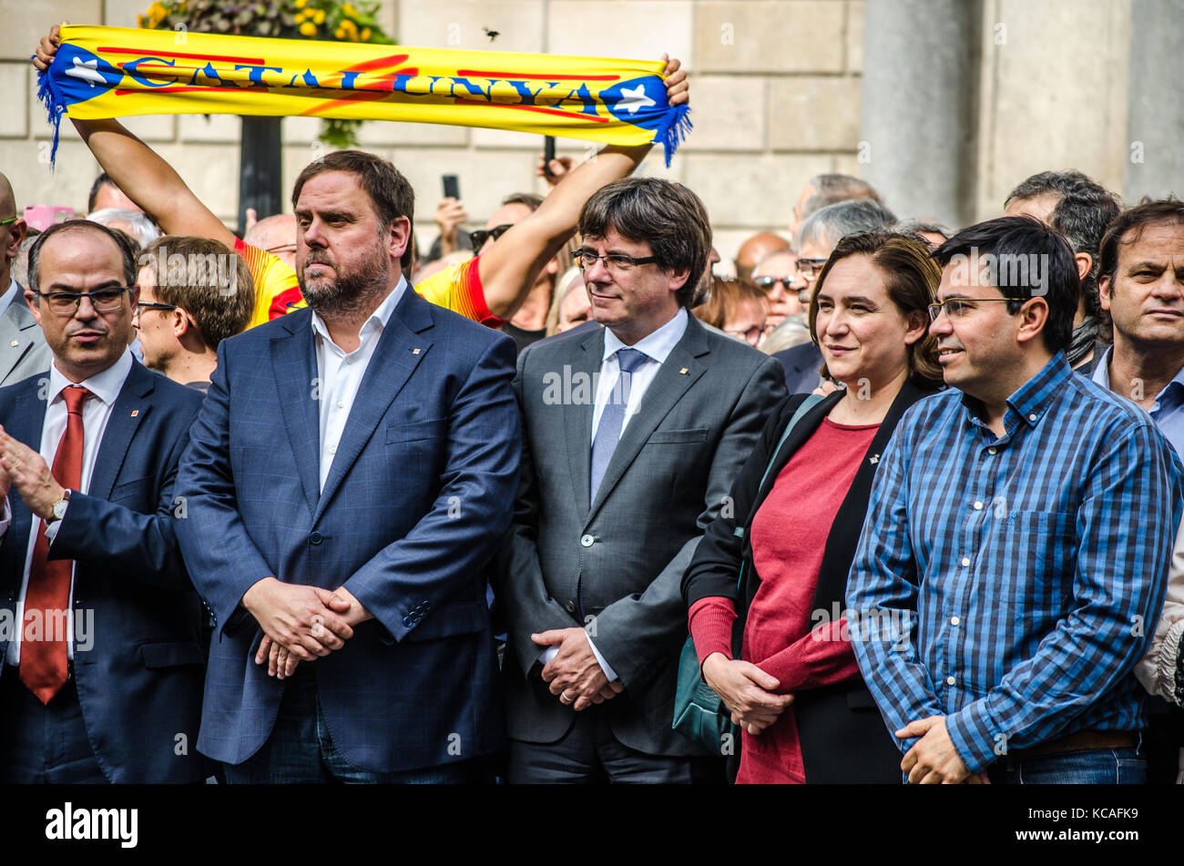 Barcelona, Spain. 3rd Oct, 2017. The Government of the Generalitat are seen during the minute of silence, while a man raising in the air a Catalonia scarf. The Catalan Government and the city of Barcelona gathered for a minute of silence as a sign of rejection against Police brutality, in the San Jauma Plaza, headquarters of both administrations. Stock Photo