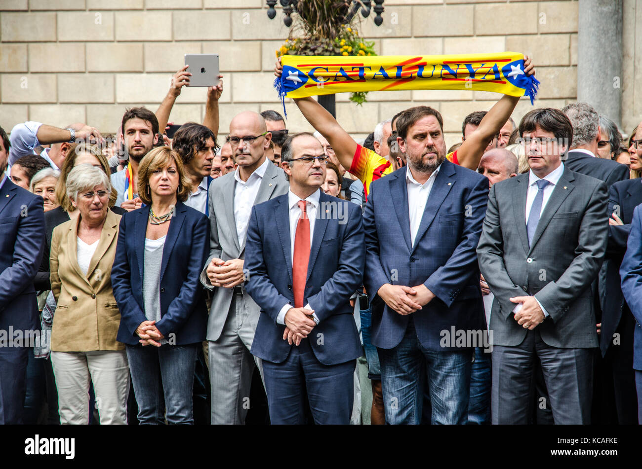 Barcelona, Spain. 3rd Oct, 2017. The Government of the Generalitat are seen during the minute of silence, while a man raising in the air a Catalonia scarf. The Catalan Government and the city of Barcelona gathered for a minute of silence as a sign of rejection against Police brutality, in the San Jauma Plaza, headquarters of both administrations. Stock Photo