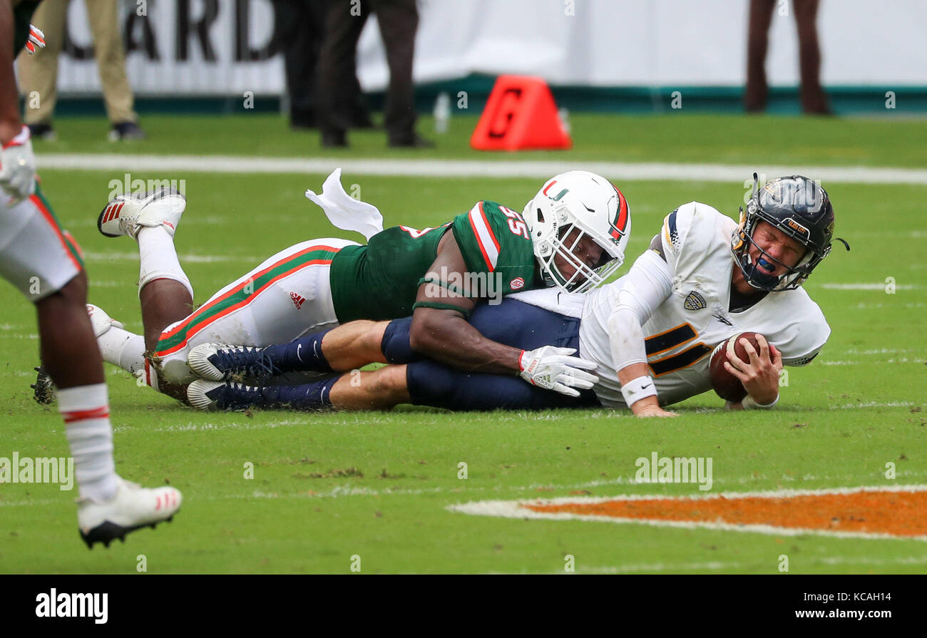 Miami Gardens, Florida, USA. 23rd Sep, 2017. Toledo Rockets quarterback Logan Woodside (11) gets tackled by Miami Hurricanes linebacker Shaquille Quarterman (55) during the college football game between the Toledo Rockets and the Miami Hurricanes at the Hard Rock Stadium in Miami Gardens, Florida. Miami won 52-30. Mario Houben/CSM/Alamy Live News Stock Photo