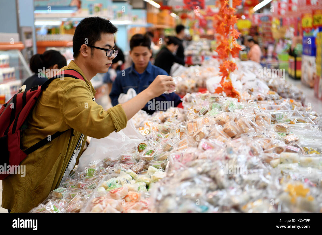 (171004) -- HEFEI, Oct. 4, 2017 (Xinhua) -- Customers choose simply-packaged mooncakes at a market in Hefei, east China's Anhui Province, Oct. 4, 2017. China has promoted simple packaging drive which would help spread consumption concepts of frugality, rationality and health in recent years. This year's Mid-Autumn Festival falls on Oct. 4. Mid-Autumn Festival, the 15th day of the eighth month on China's lunar calendar, is an occasion for family gatherings and well-known as the time to eat mooncakes. (Xinhua/Liu Junxi)(wsw) Stock Photo