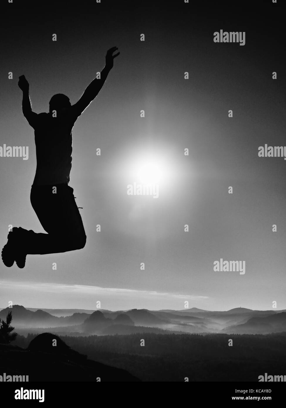 Jumping man. Young crazy man is jumping on colorful sky background.Silhouette of jumping man and beautiful sunset sky. Element of design. Vintage effe Stock Photo