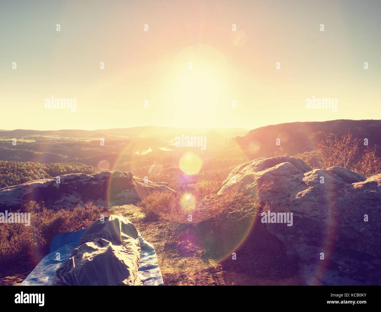 Sleeping in nature in sleeping bag. Beautiful awakening in rocks. View