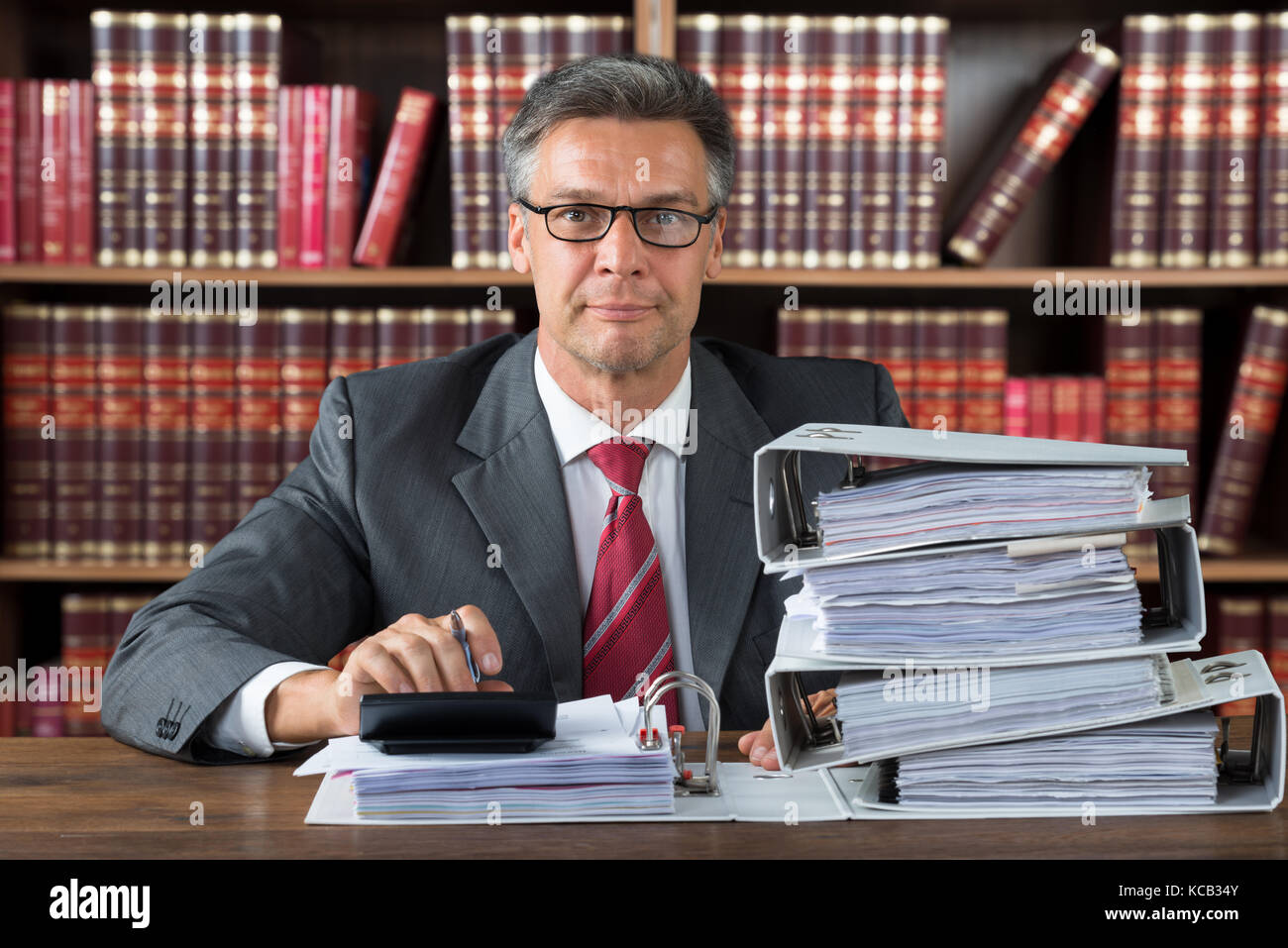 Portrait Of A Male Accountant Working With Stacked Folders On Wooden ...