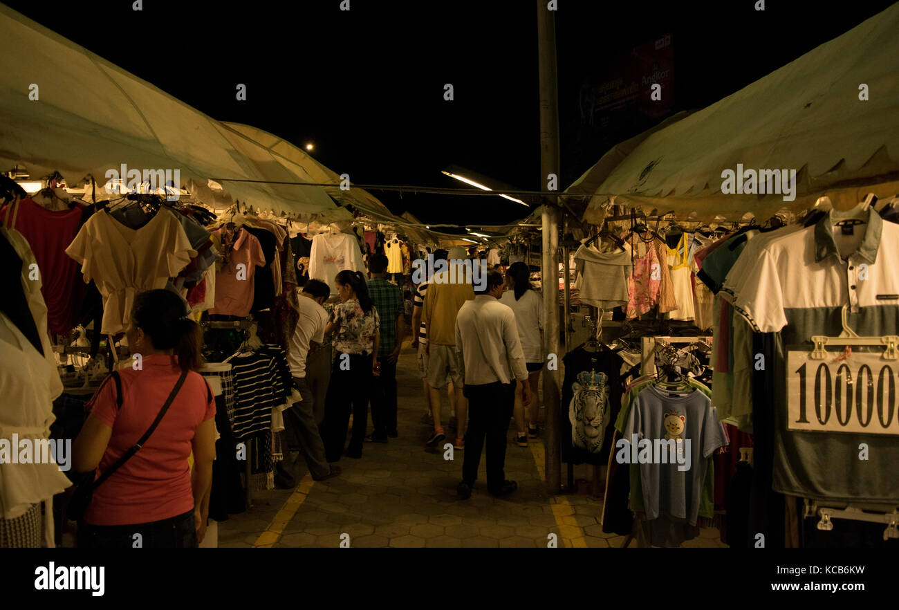 A corridor between stalls selling clothes at the Phnom Penh night market in Cambodia, South East Asia. Many t-shirts on display, cheap prices Stock Photo