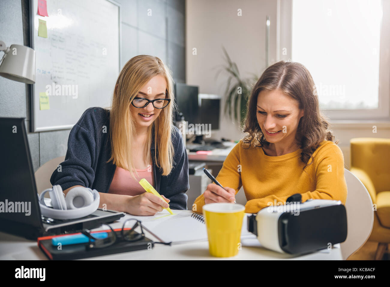 Two business woman working together at the office Stock Photo - Alamy