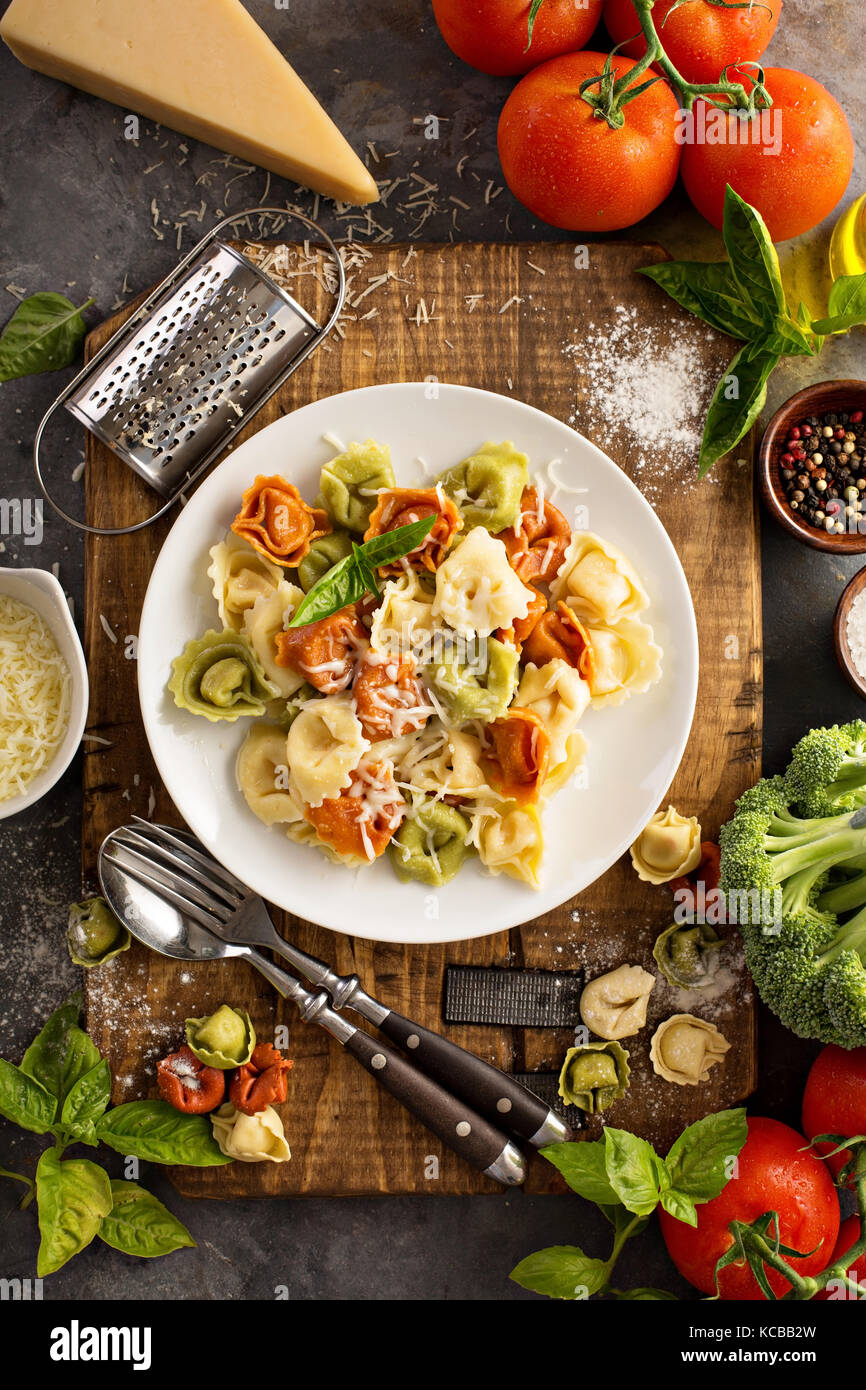 Red, white and green tortellini with vegetables and cheese Stock Photo