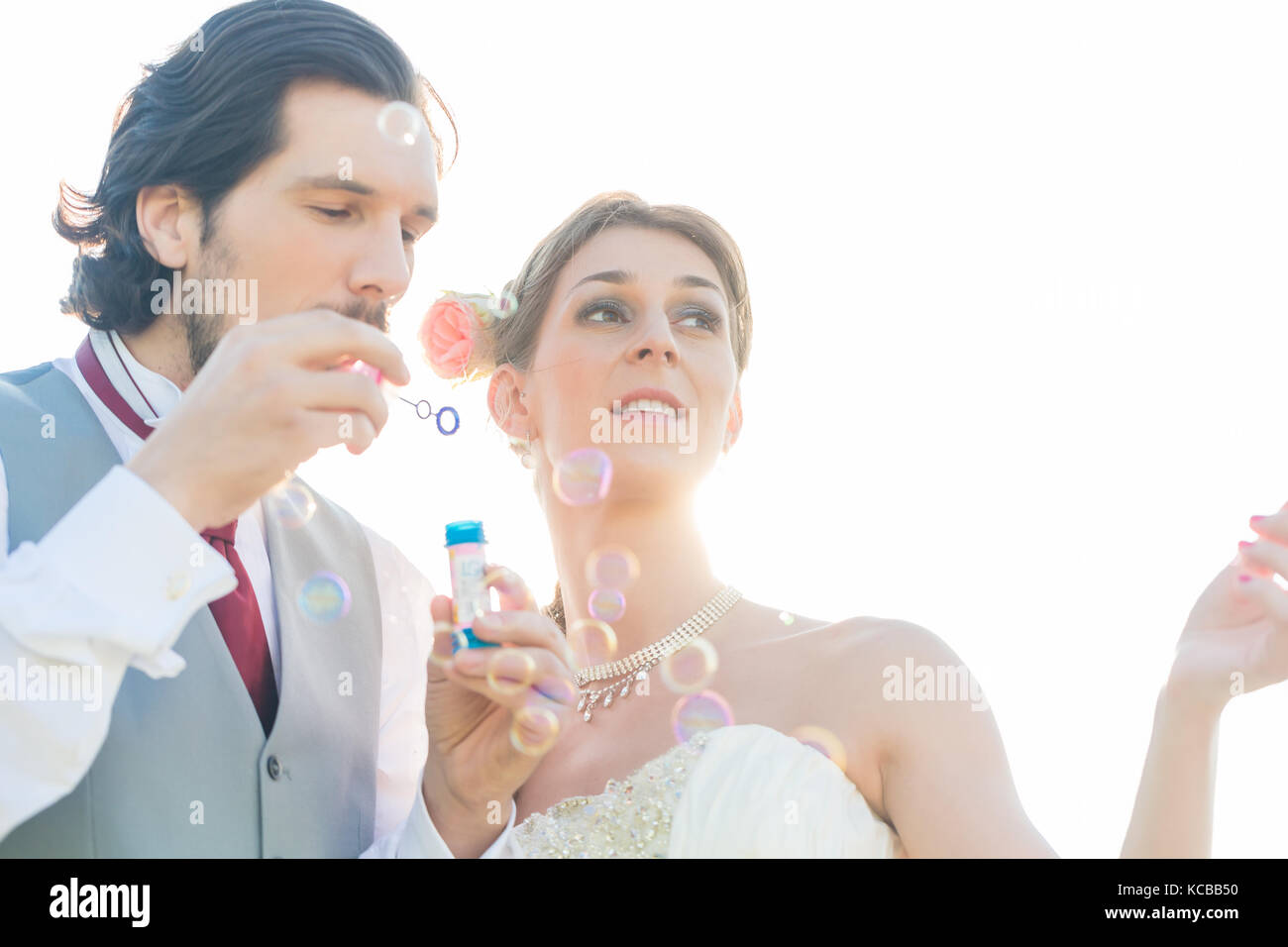 Wedding couple blowing soap bubbles outside Stock Photo Alamy