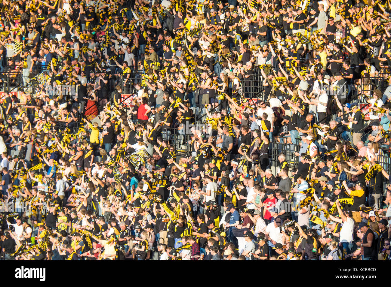 Richmond Football Club Fans Standing And Cheering On Their Team At The 