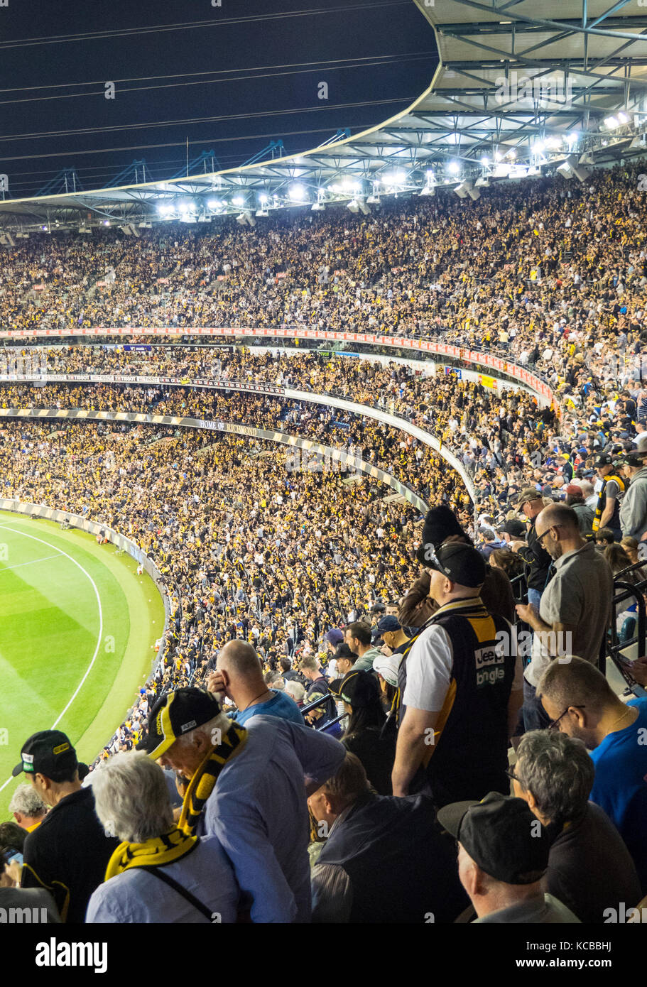 Richmond Football Club Fans Standing And Cheering On Their Team At The 
