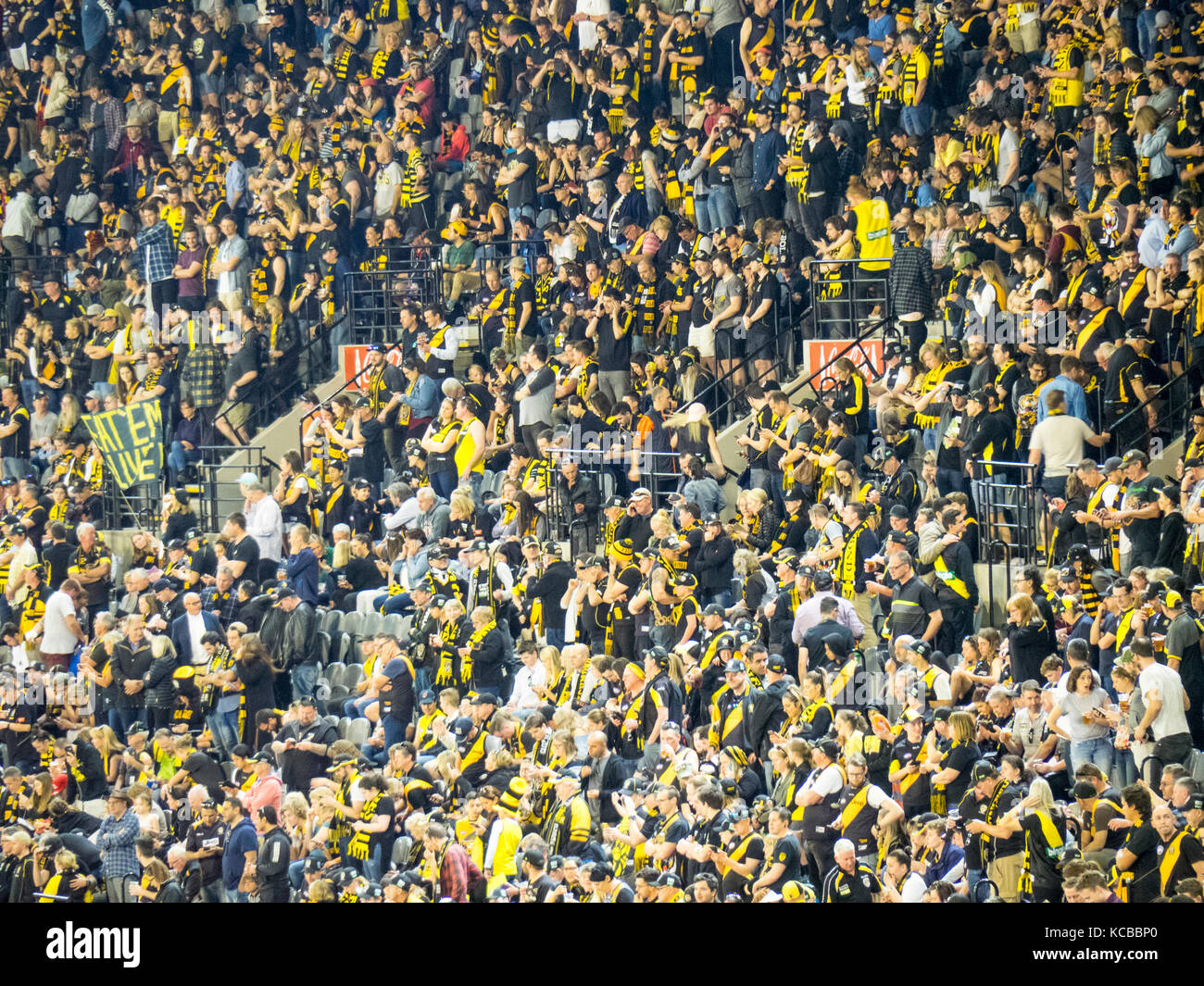 Richmond Football Club Fans Standing And Cheering On Their Team At The 
