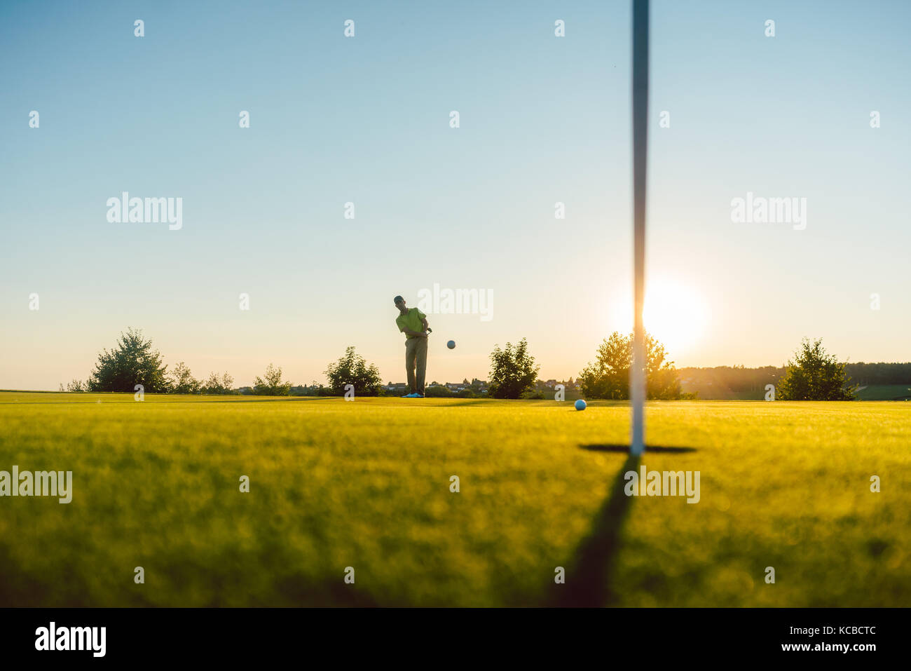 Silhouette of a male player hitting a long shot on the putting g Stock Photo