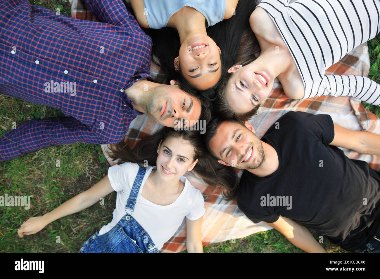 Five Cheerful Friends Lying On Grass Top View Portrait Happy Young Stock Photo Alamy