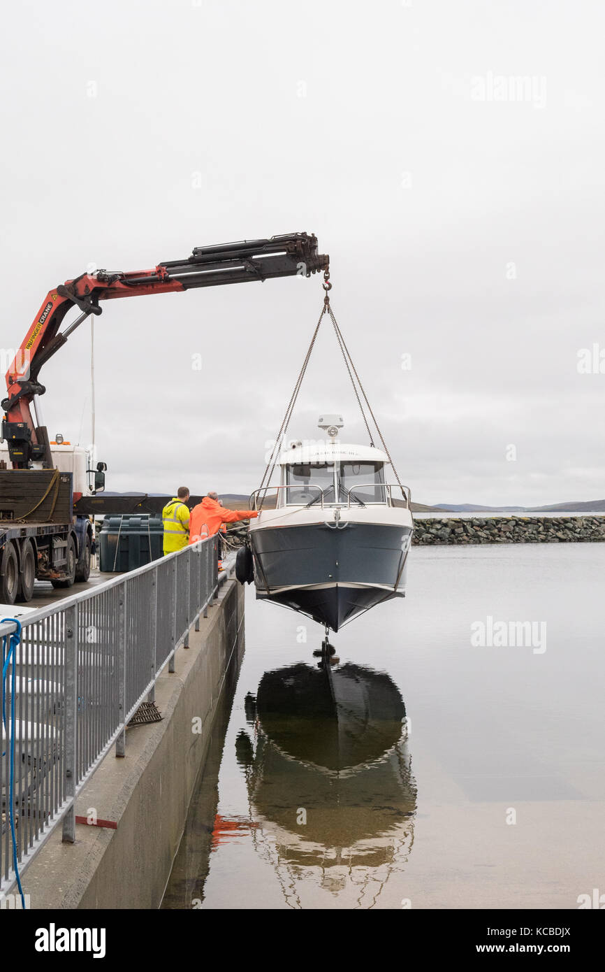 crane lifting a small boat at Delting Boating Club Marina and caravan park, Brae, Shetland Islands, Scotland, UK Stock Photo