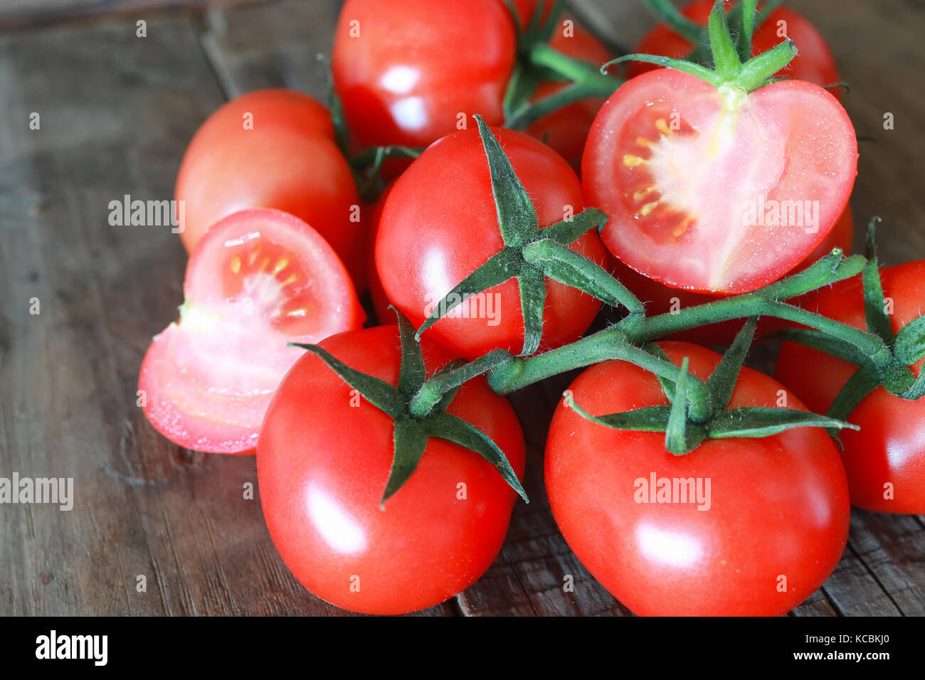 branch of tomatoes on wooden background Stock Photo - Alamy