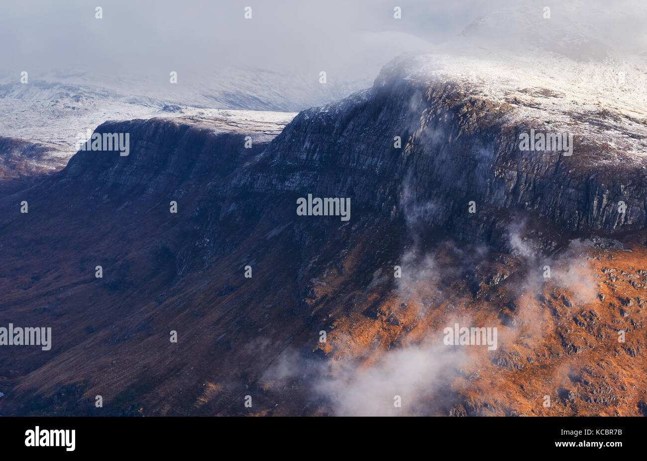 A snow and cloud covered summit of Beinn A Mhuinidh above Loch Maree in the Scottish Highlands, Scotland, UK. Stock Photo