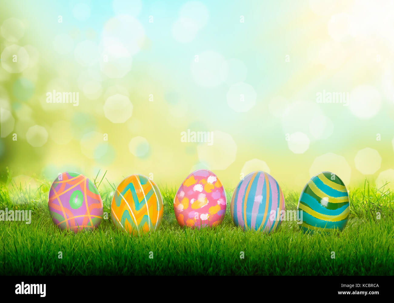 Colourful painted Easter Eggs on green grass and blurred garden, sunny ...