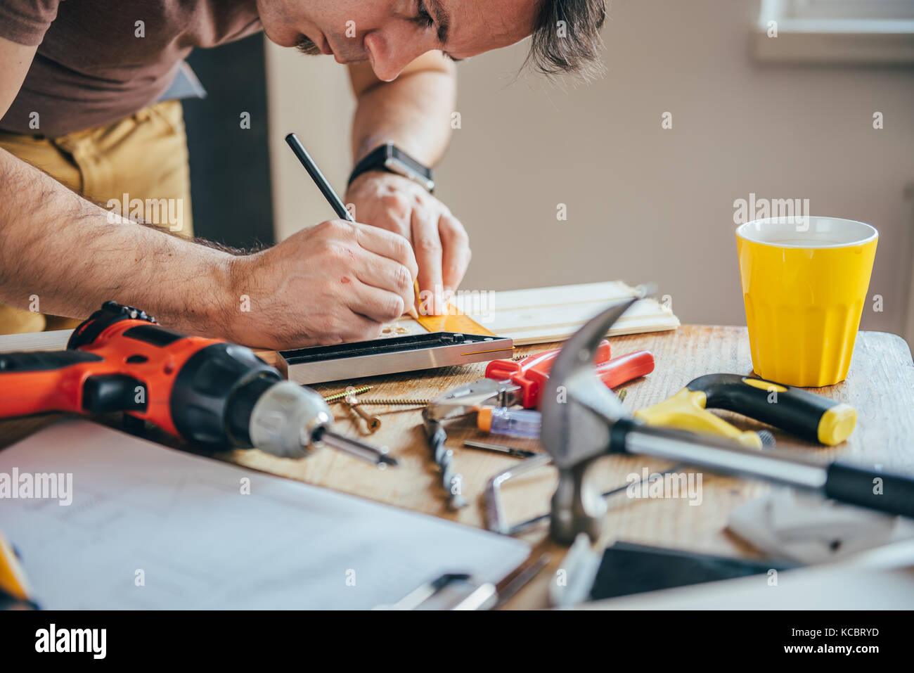 Man marking wood at home during renovation of living room Stock Photo