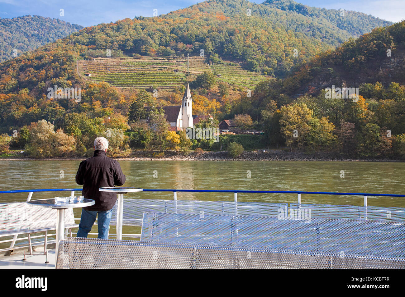 An unidentified traveler views the fall scenery and vineyards, Wachau Valley, Danube River, Austria. Stock Photo