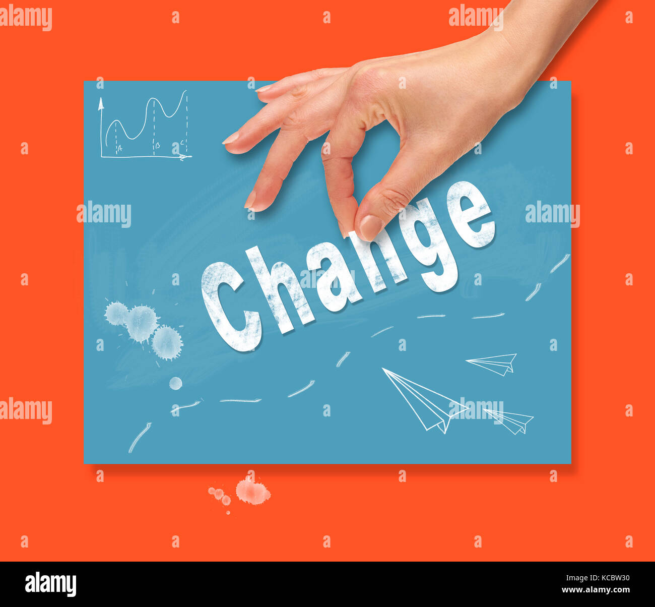 A hand picking up a Change concept on a colorful drawing board. Stock Photo