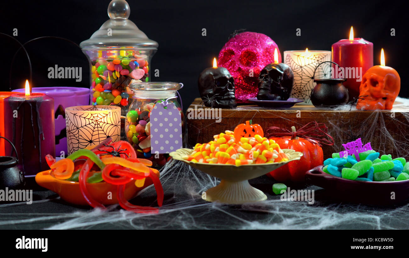 Halloween trick or treat party table with bowls and apothecary jars of