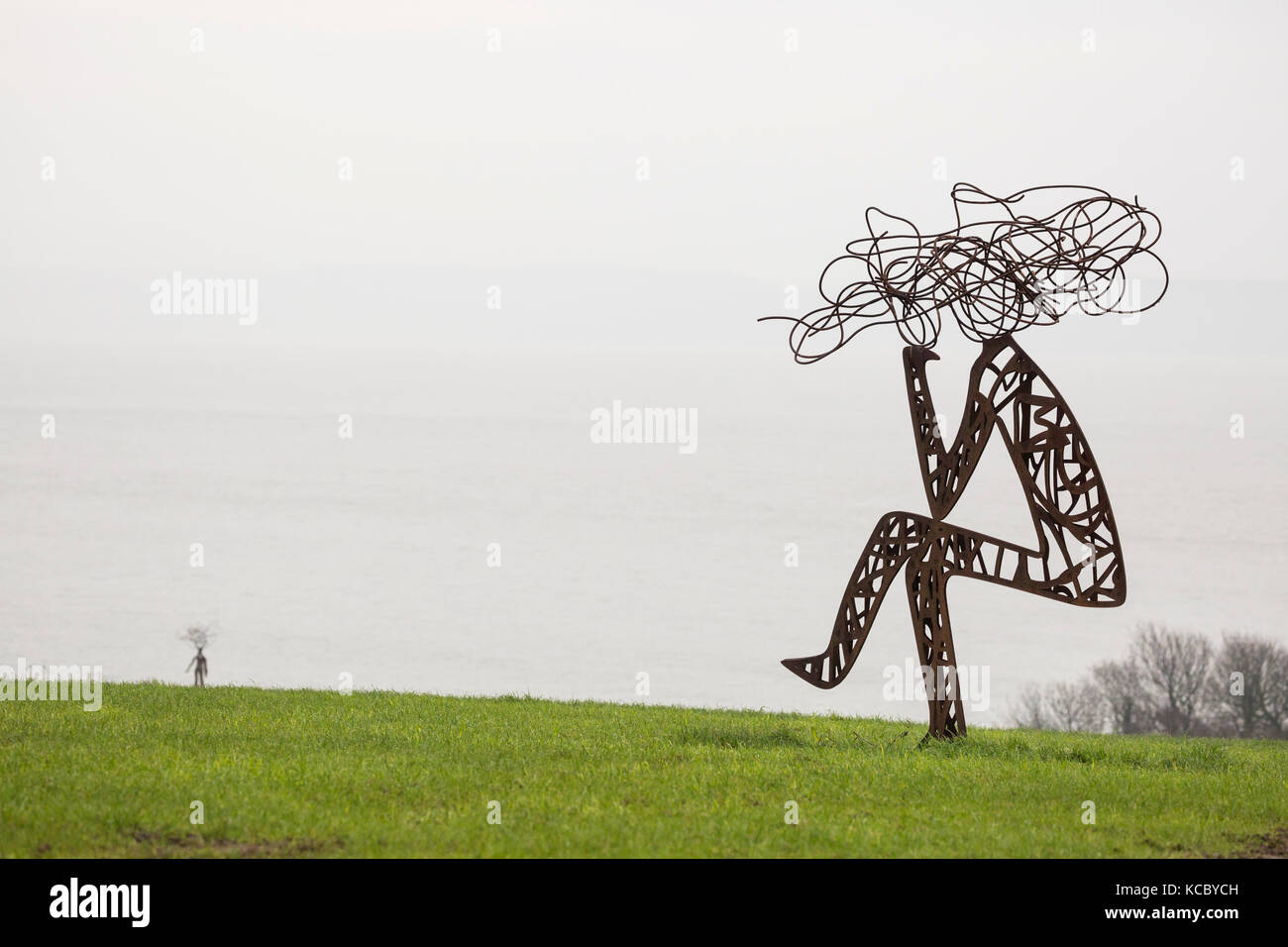 outdoor metal sculpture of stylised men in field Stock Photo