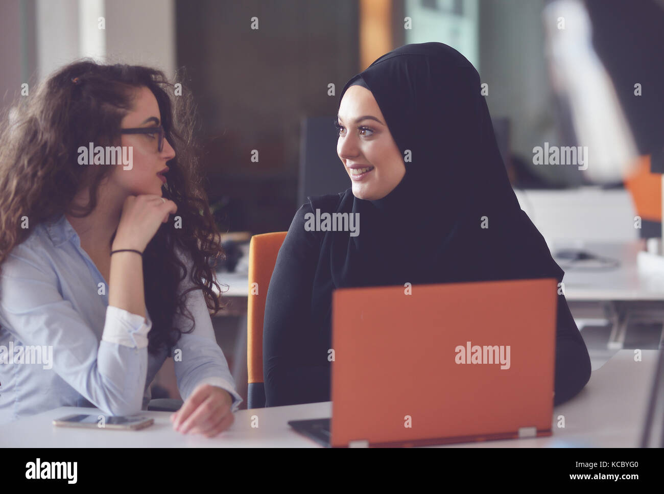Two Muslim business woman working on their laptop Stock Photo - Alamy