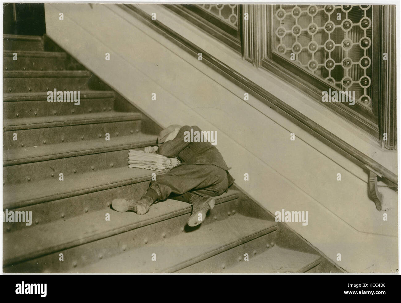 Newsboy asleep on stairs with papers, Jersey City, New Jersey, Lewis Hine, February 1912 Stock Photo