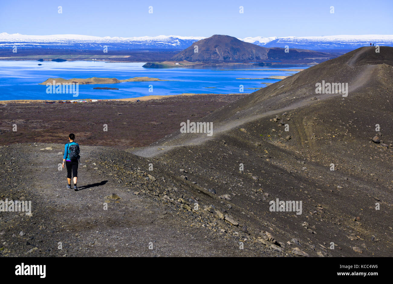 Hikers at Hverfell (also called Hverfjall) tephra cone or tuff ring volcano with Mývatn lake in the background. Iceland. Stock Photo