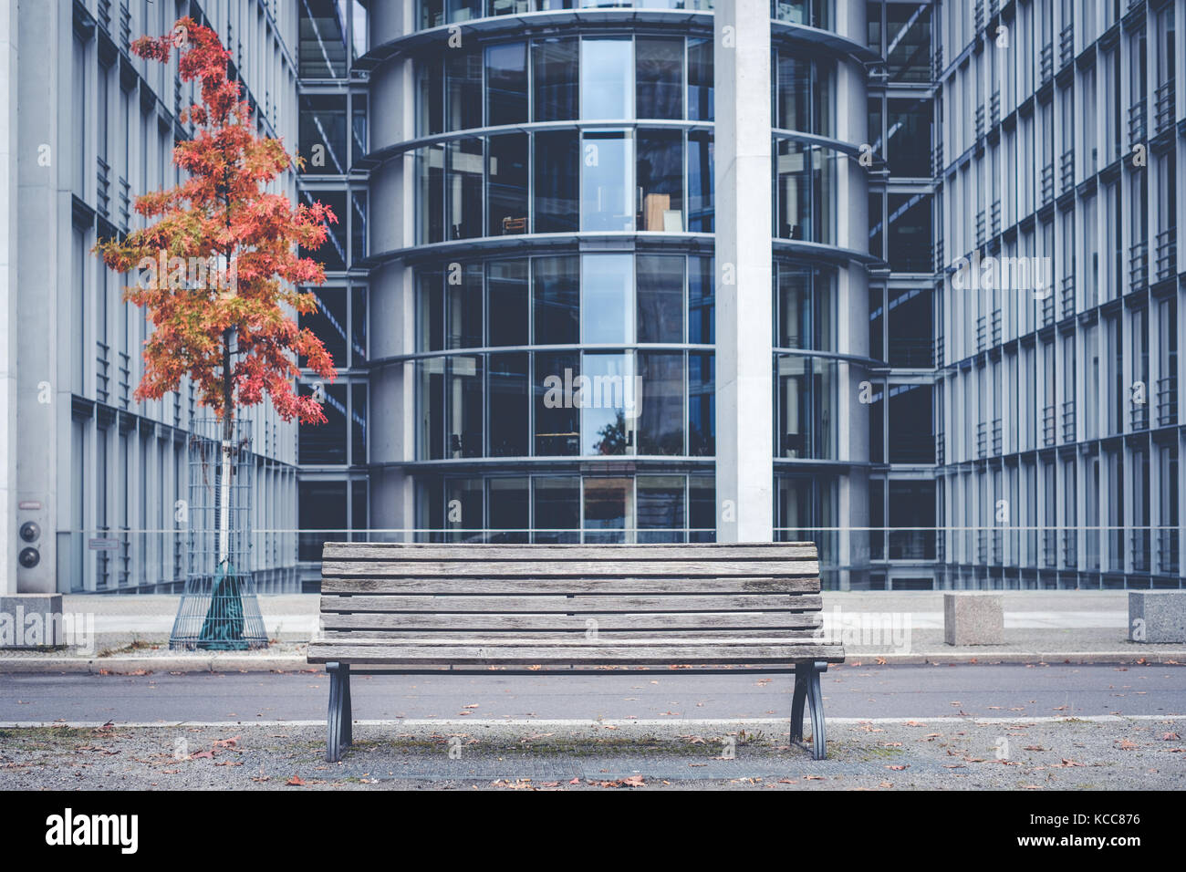 empty wooden bench outside modern office building - Stock Photo