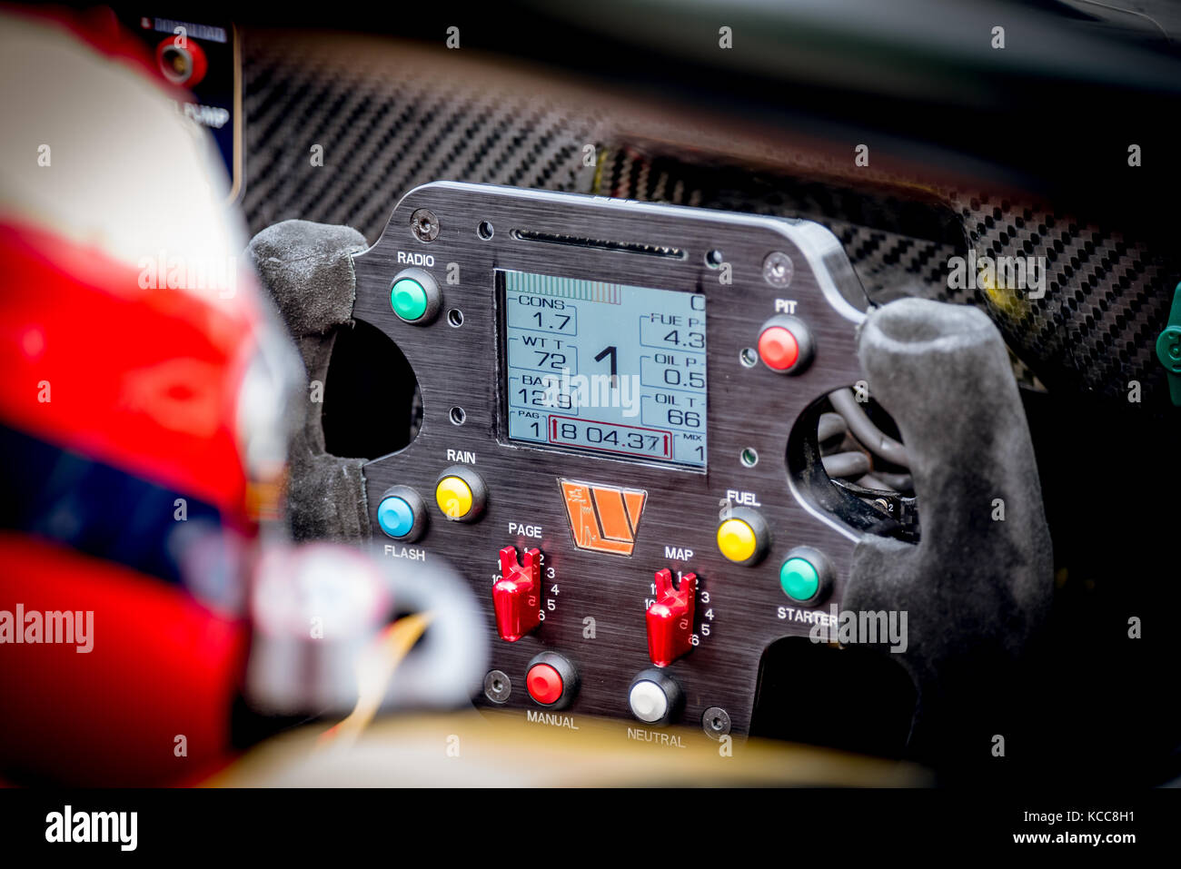 Racing car steering wheel with pushbutton commands close up and first gear signal Stock Photo