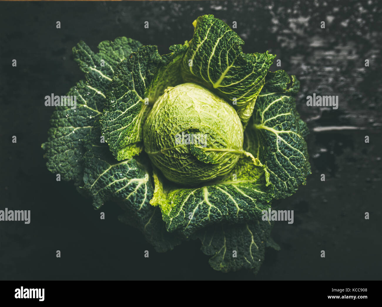 Raw fresh green cabbage over dark background Stock Photo