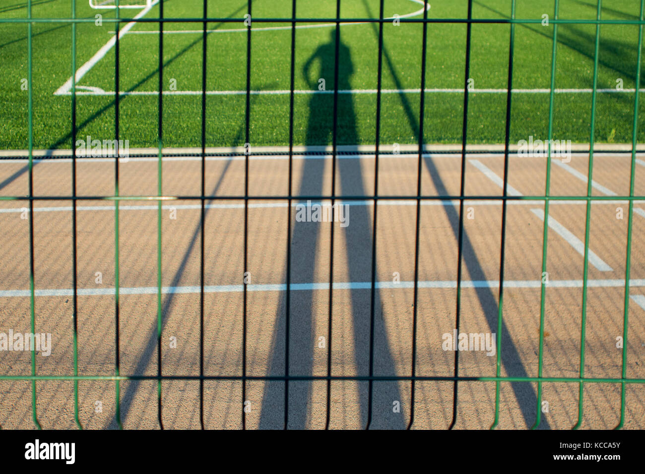 Want to play sports, the person watching the Playground through the fence, shadow Stock Photo